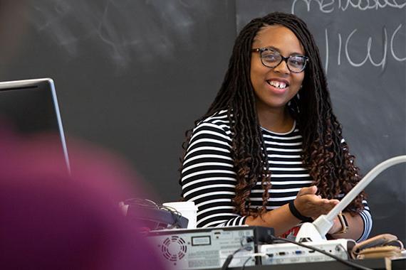 Graduate student teaching assistant in front of classroom